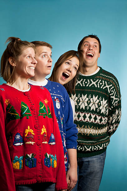 Look up, it's sweaters! A group of ugly sweater wearing adults looking up christmas sweater photos stock pictures, royalty-free photos & images