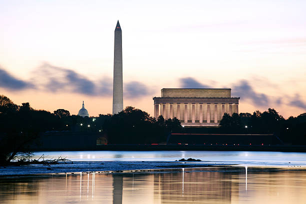 Washington DC at Dawn The sun rises behind the Lincoln Memorial, the Washington Monument and the US Capitol. washington monument washington dc stock pictures, royalty-free photos & images