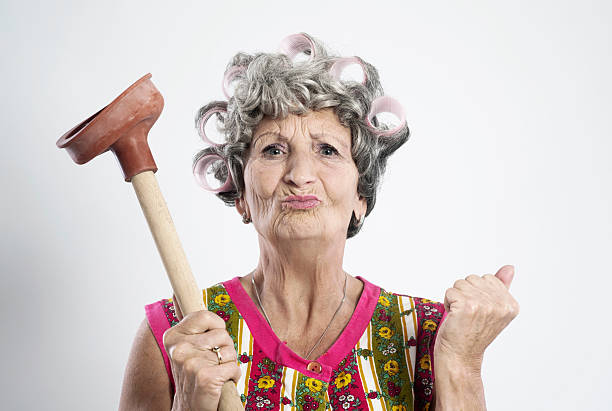Angry elderly housewife Stereotype housewife, 68 years old, with curlers in her hair. ugly old women stock pictures, royalty-free photos & images