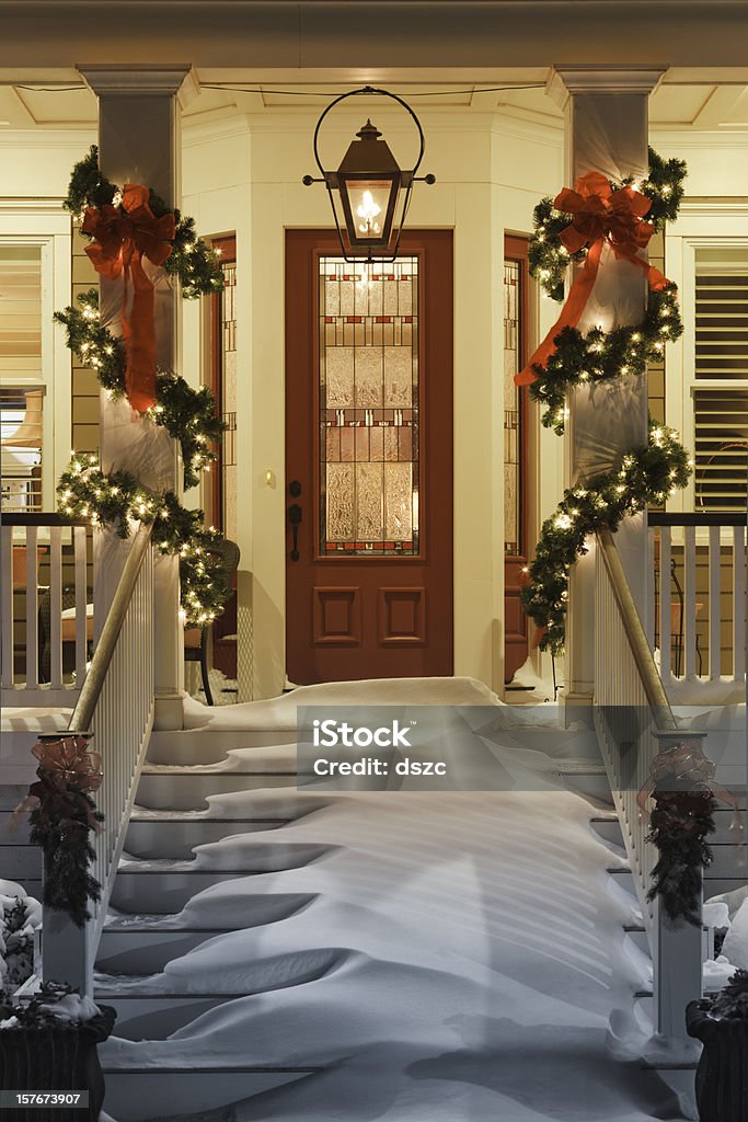 inviting Christmas doorway with snow on porch stairs and railing  Christmas Stock Photo