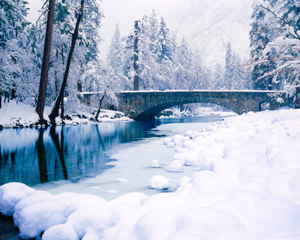 Winter In Yosemite National Park Falling Snow Creates A Winter Wonderland In Yosemite National Park Along The Merced River snowy river stock pictures, royalty-free photos & images