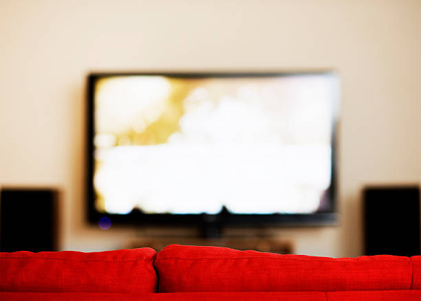 istock Looking over the back of a red sofa at television 157674062