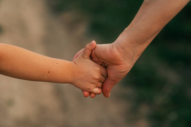 istock Hand in hand mom and daughter, giving psychological help, supporting outdoors at sunset, close up 1576742442