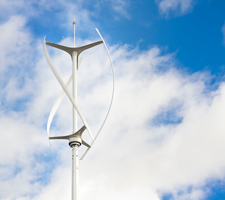 Motion blur as a small, vertical-axis wind turbine spins.  This type of wind turbine is normally used in a city environment.