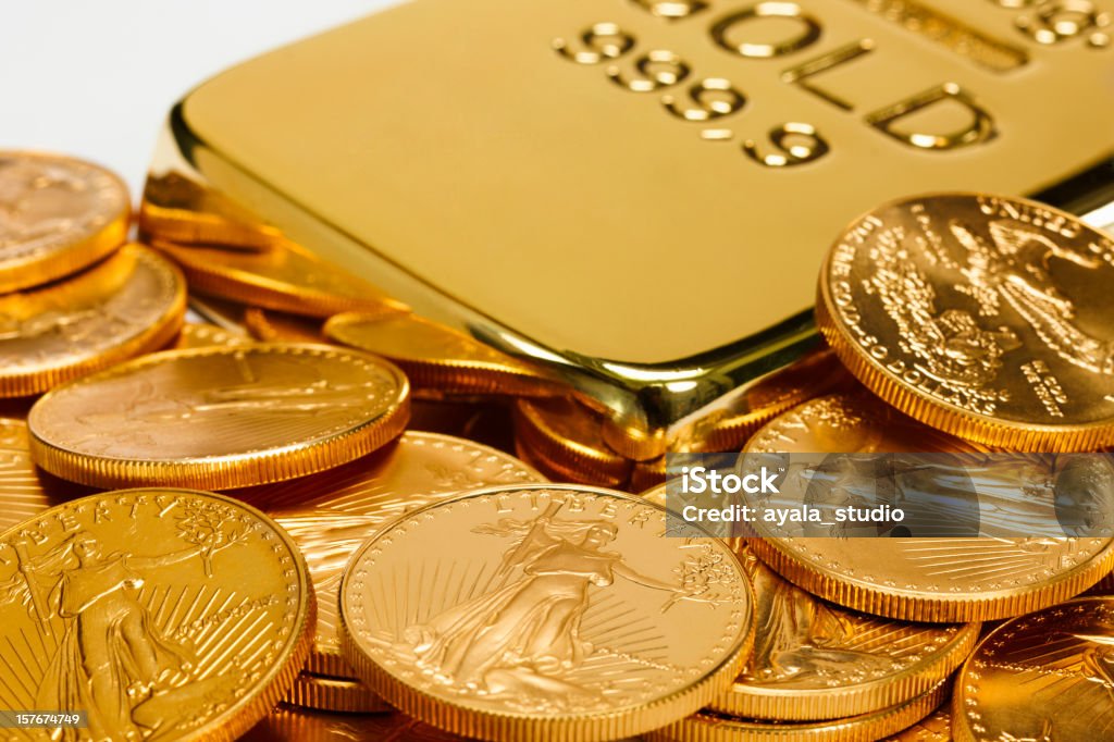 Gold ingot surrounded by golden coins Gold Ingot and Coins Ingot Stock Photo