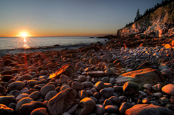 Rocky shoreline of Acadia National Park on calm weather day in early summer in Maine