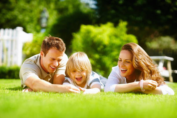 istock Middle aged couple with son lying on grass in park 157674948