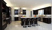 A brightly lit modern kitchen with bar stools