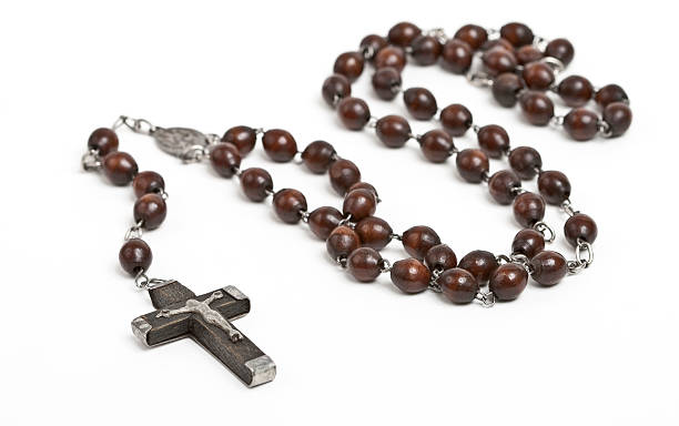 Wooden rosary beans laid across a white table