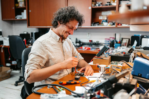 istock Young Man Repairing Electronic Equipment In A Workshop 1576751988