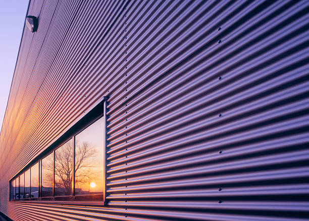 夕暮れの倉庫でウィンドウを反映しています。 - corrugated iron ストックフォトと画像