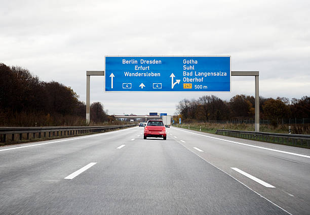 Lisbon, Portugal, November 17, 2024, Dark gray car driving on highway approaching fuel price information sign eight kilometers ahead in portugal