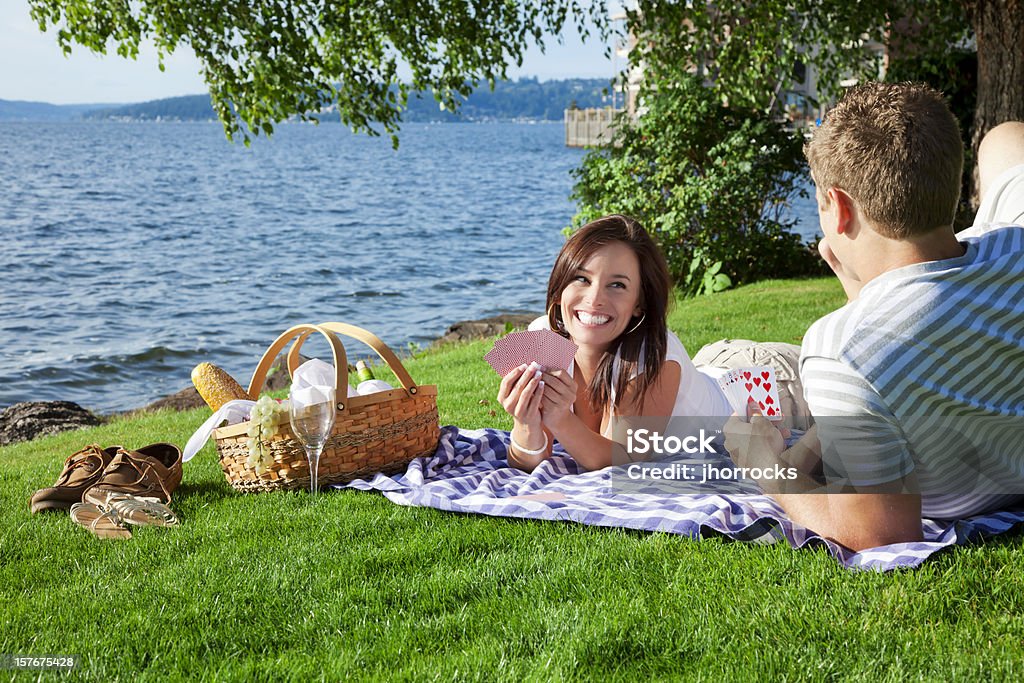 Jovem casal fazendo um piquenique no parque - Foto de stock de Carta de baralho - Jogo de lazer royalty-free