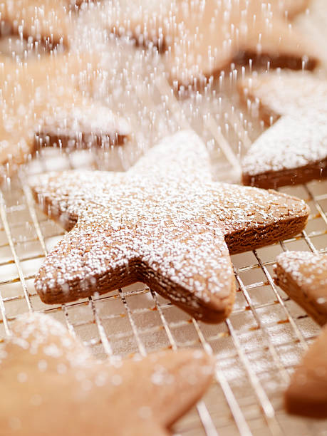 Gingerbread Cookies Being Sprinkled with Powdered Sugar  sprinkling powdered sugar stock pictures, royalty-free photos & images