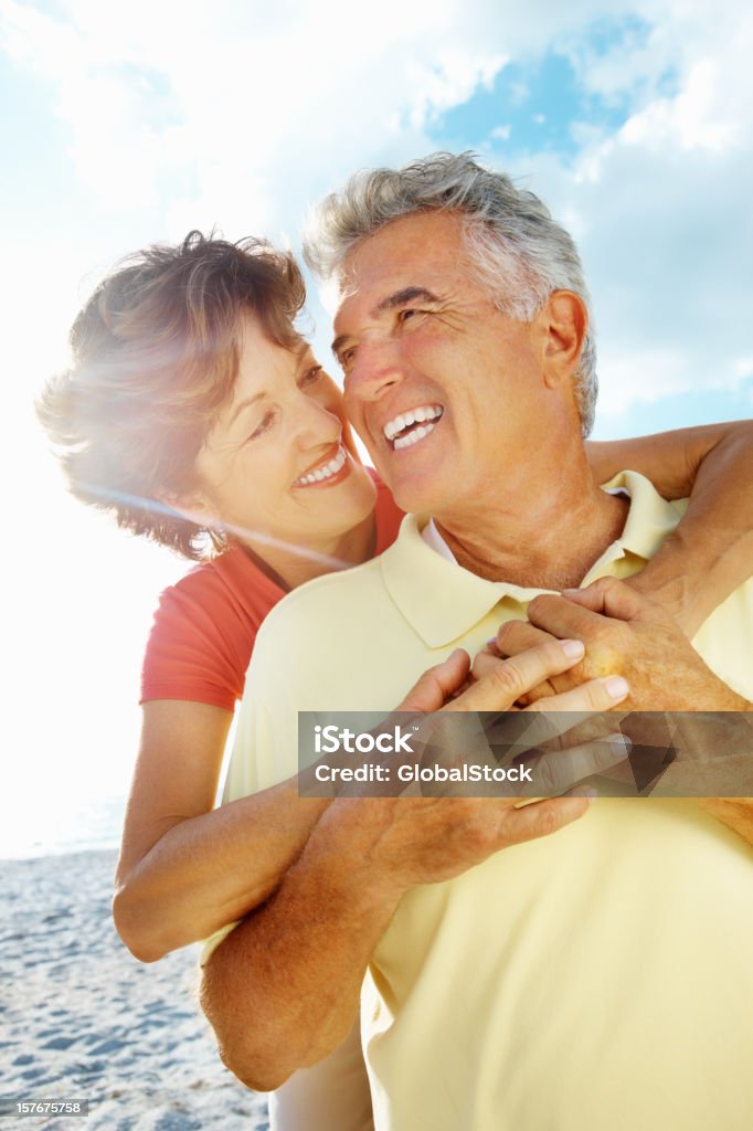 Lächelnd senior Frau umarmen Mann von hinten auf den Strand - Lizenzfrei Paar - Partnerschaft Stock-Foto