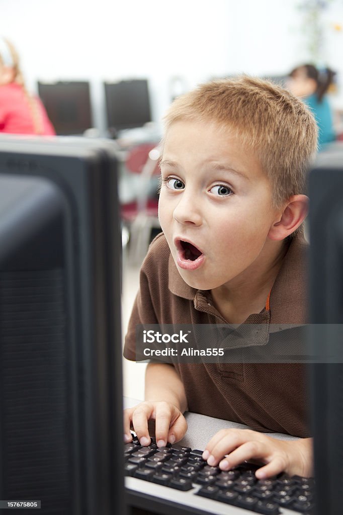 Удивлен Маленький мальчик в Компьютерный класс - Стоковые фото 6-7 лет роялти-фри