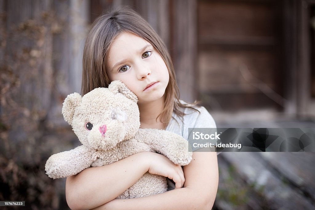 Triste jeune fille embrassant vieux, Raggedy ours en peluche - Photo de Tristesse libre de droits