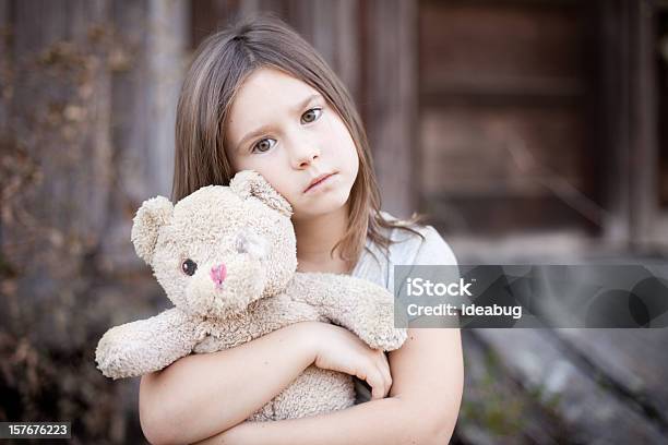 Photo libre de droit de Triste Jeune Fille Embrassant Vieux Raggedy Ours En Peluche banque d'images et plus d'images libres de droit de Tristesse