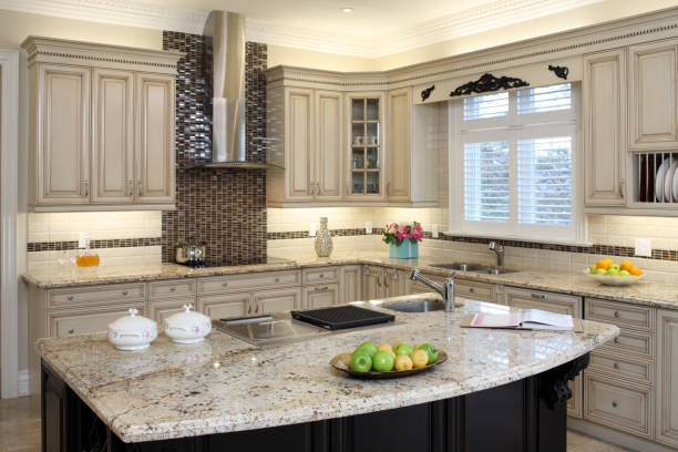 Modern gray, brown kitchen features front cabinets with granite countertops and tile backsplash with island and window