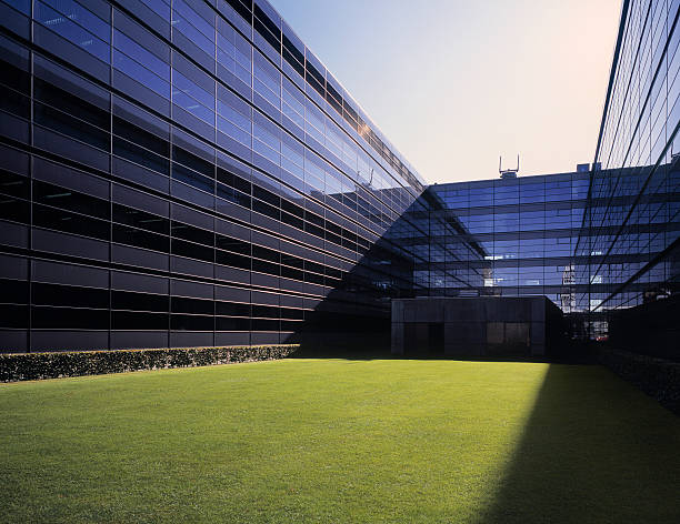 современные стеклянные офисное здание с травой поле. - glass architecture prosperity business стоковые фото и изображения