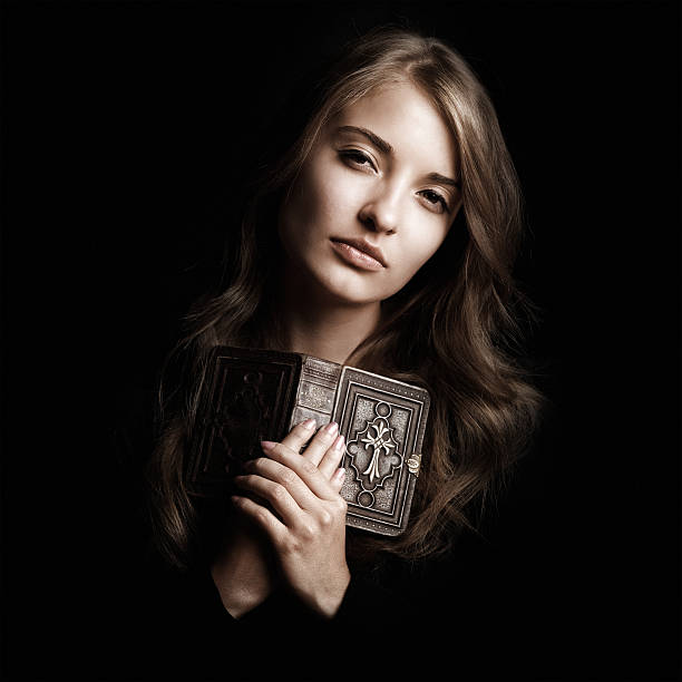 istock Catholic girl with old prayer book 157676689