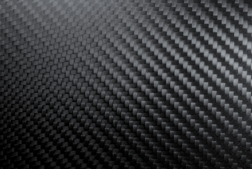 Close up of a shiny carbon fibers' texture with typical carbonium rough surface and visible fibers