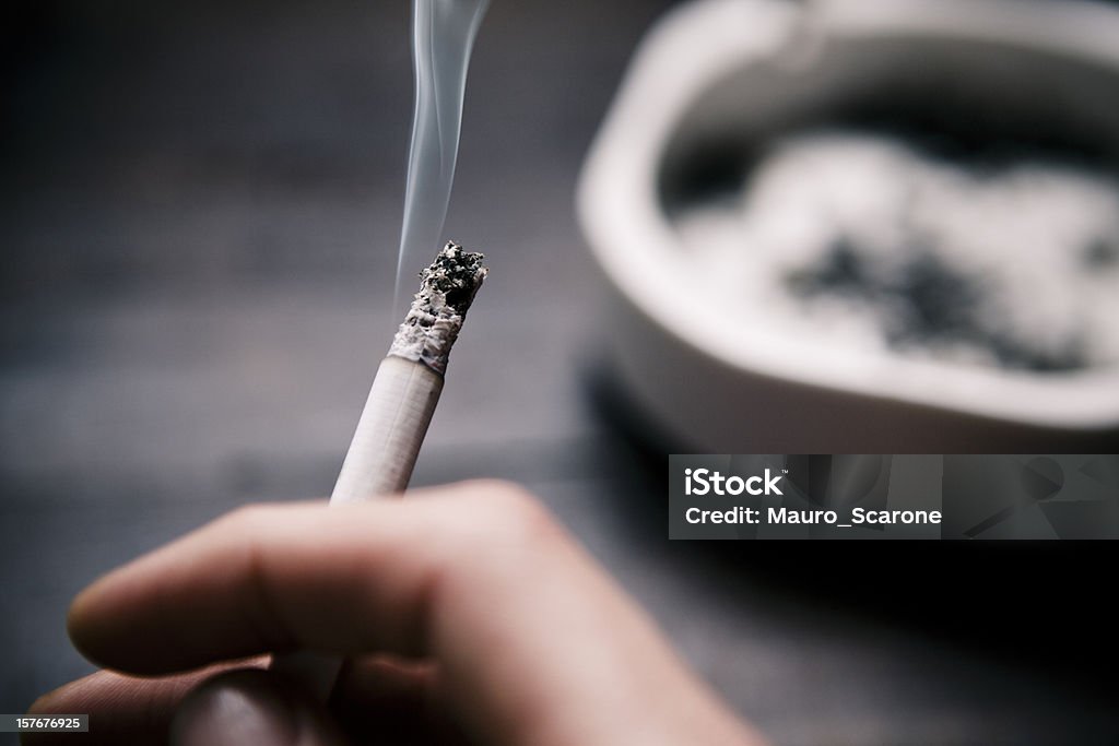 Sosteniendo un cigarrillo. - Foto de stock de Cigarrillo libre de derechos