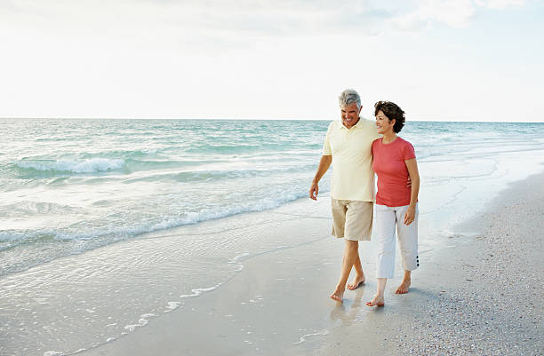 istock Loving mature couple walking at water's edge on a beach 157676976