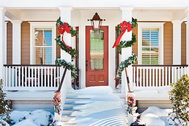 inviting christmas front doorway with snow on porch stairs - xmas tree stockfoto's en -beelden