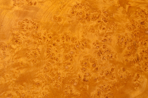 You look at a texture of the burl wood door of an old closet from the 1950ies. It has a yellow-reddish polished surface with a lively wood grain pattern. Excellent for designs or backgrounds. The dimensions of the image are 4220 px x 2803 px. Horizontal orientation.
