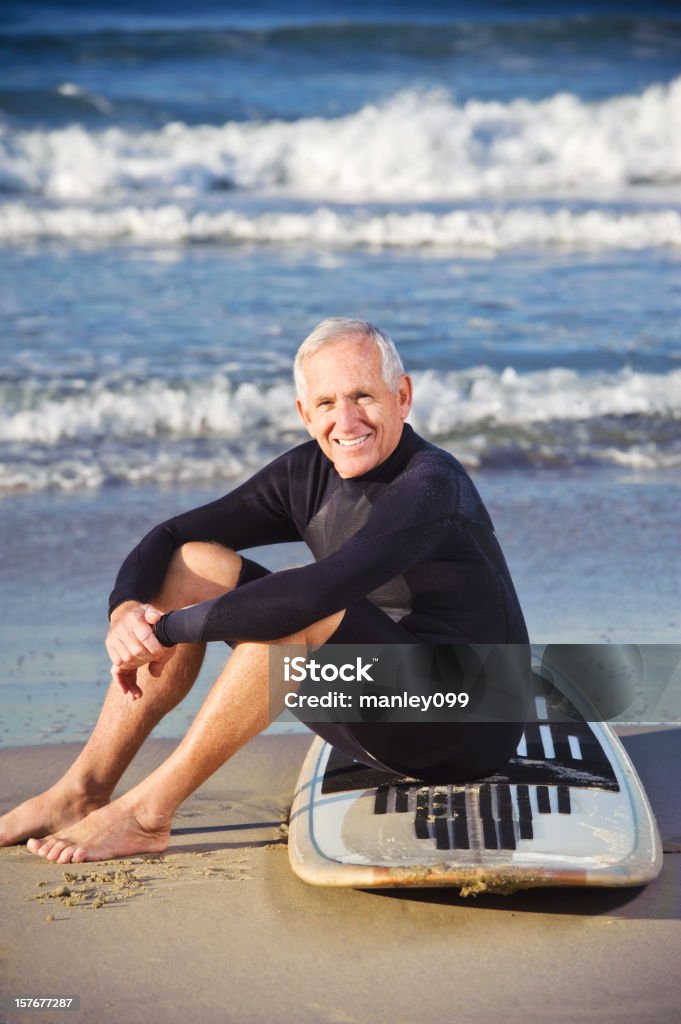 Surfista y senior sonriente sentada en tabla de surf - Foto de stock de 60-64 años libre de derechos