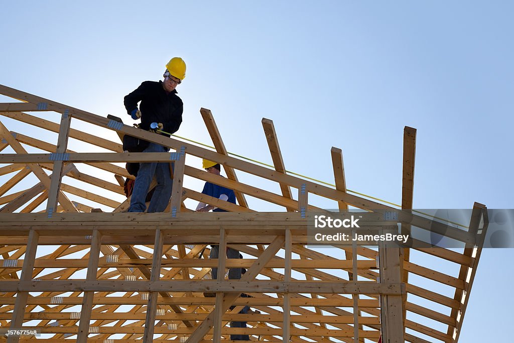 Travailleurs de la Construction sur le toit donnant à - Photo de Industrie du bâtiment libre de droits