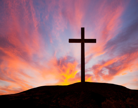 Rugged Wooden Cross Against A Sunset Sky
