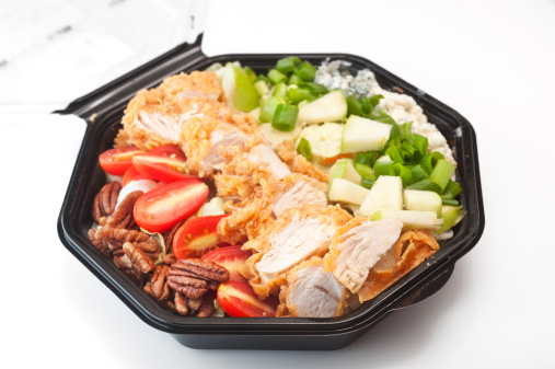 Set of sushi to go in a plastic container on a gray background, japanese cuisine