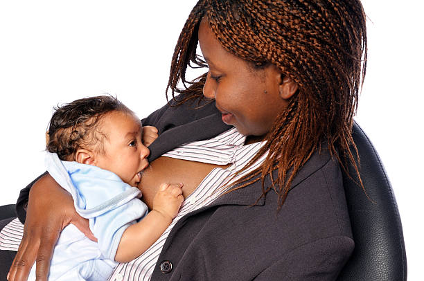 afro-americana donna d'affari alla ricerca al suo bambino durante l'allattamento al seno - baby1 foto e immagini stock