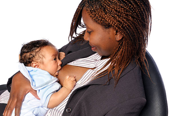 афро-американских женщина, глядя на ее ребенка во время кормления грудью - baby1 стоковые фото и изображения