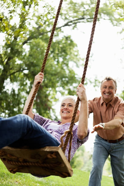 istock Senior Couple Playing on a Park Swing 157677989