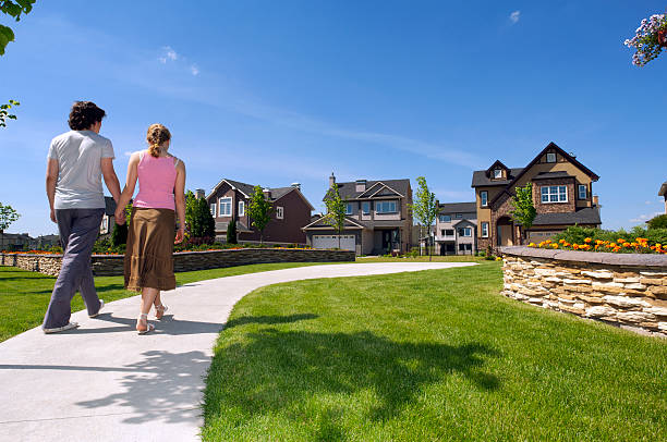 casal jovem caminhando para sua nova casa suburbana. - lawn residential district landscaped community - fotografias e filmes do acervo