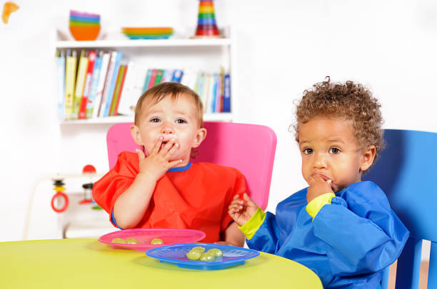 biracial niño bebé/niño comiendo frutas frescas y bibliografía - plastic ring fotografías e imágenes de stock