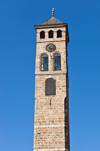 Close up of a belfry with a weather vane on top.