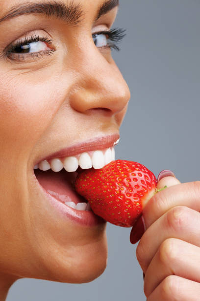 istock Cheerful young woman eating fresh strawberry 157678449