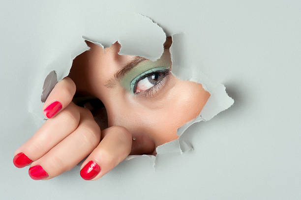 istock Young woman looking out through hole 157678463