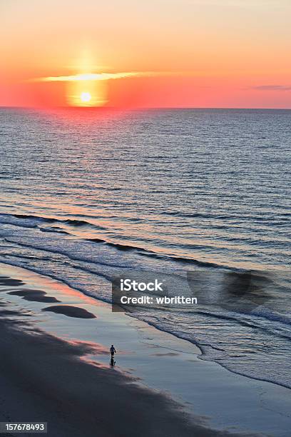 Solitary Walker With Ocean Sunrise Or Sunset Stock Photo - Download Image Now - Beach, Breaking Wave, Coastline