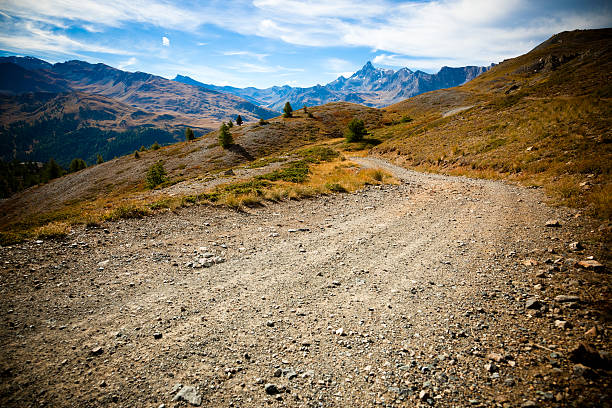 país carretera de tierra en la región de los alpes - single lane road road sky dirt road fotografías e imágenes de stock