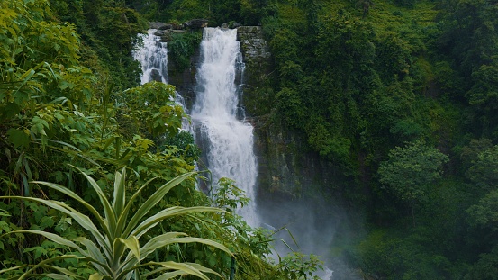 Ramboda Falls. Sri Lanka. Powerful stream of water in rocky mountains. High quality 4k footage. Waterfall cascade in tropical forest. Distant view. Nuwara Eliya.