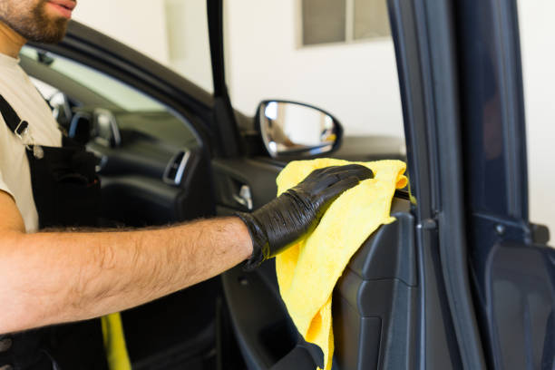 istock Male cleaner cleaning car door panel with microfiber cloth 1576787135