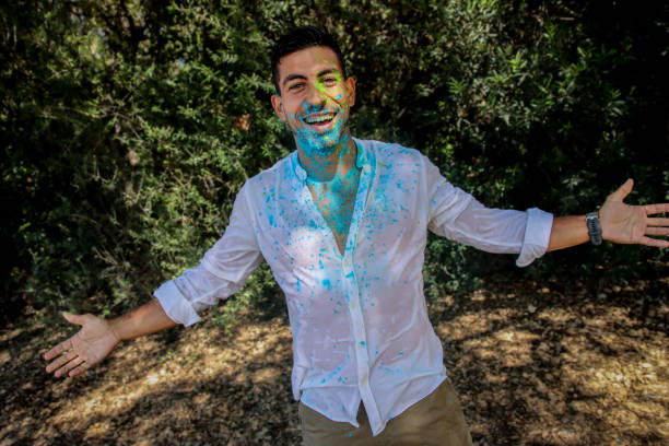 istock Young man covered in holi powder at the park 1576787687