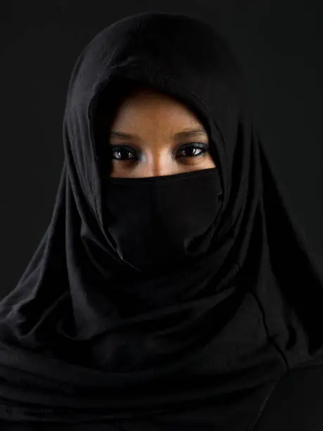 Beautiful muslim teenage girl posing on black background (this picture has been taken with a Hasselblad H3D II 31 megapixels camera)