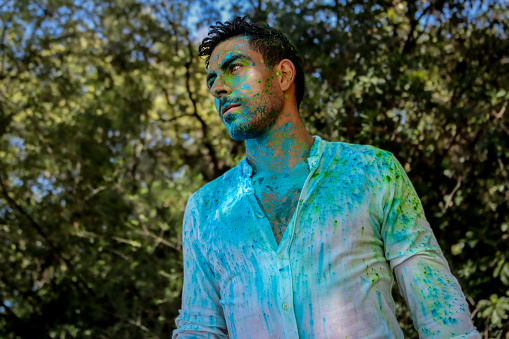 Man sprayed with holi powder yellow and green