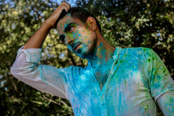 istock Young man covered in holi powder at the park 1576788201